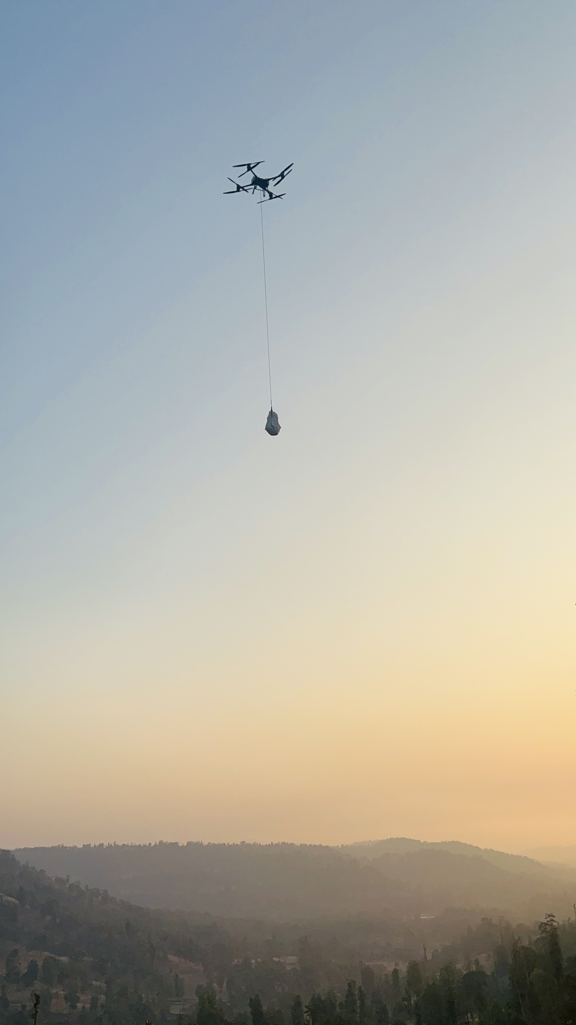 Heavy-lift drone carrying a payload over remote terrain